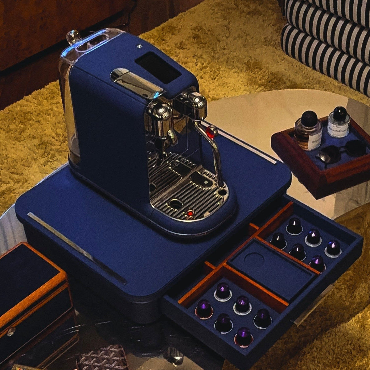 The Elemento console in Blu Notte leather with its espresso machine and capsule drawers open